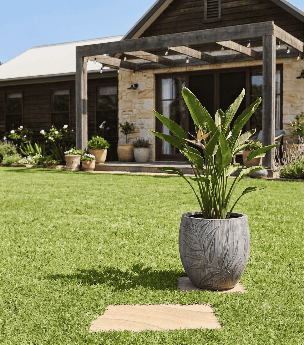 Outdoor patio garden decorated with tall embossed palm leaf planters