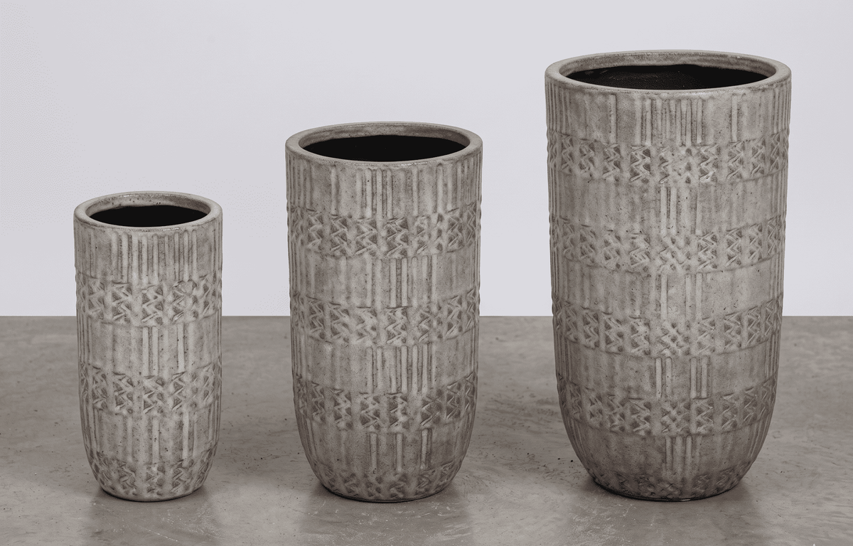 Three textured FiberClay Planter pots of different sizes on a gray surface with a white background